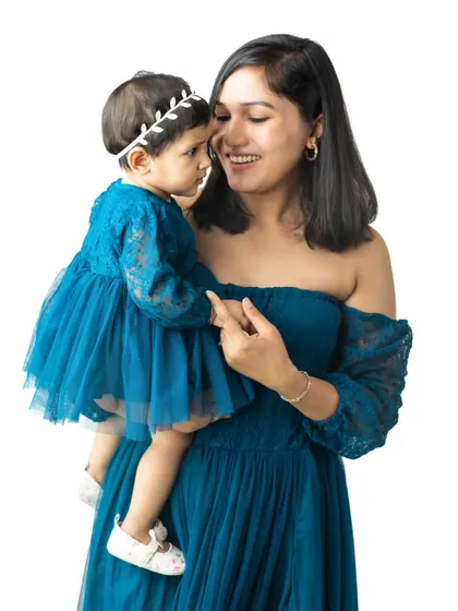 A mother and daughter, dressed in matching shades of blue, share a loving gaze in this beautiful studio portrait.