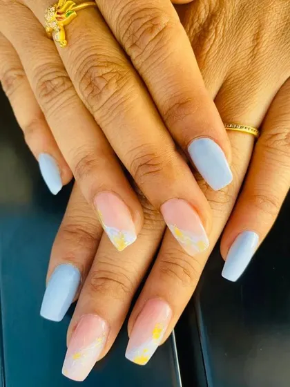 This set combines solid pastel blue nails with accent nails featuring a delicate marble design in pink and yellow. It's a sweet and cheerful combination.