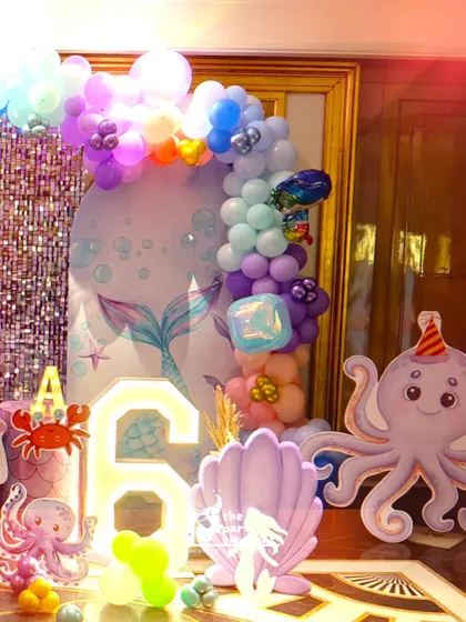 A detailed shot of the decor, featuring a light-up number '6', a large seashell prop, and a cute octopus cutout, all contributing to the under-the-sea vibe.
