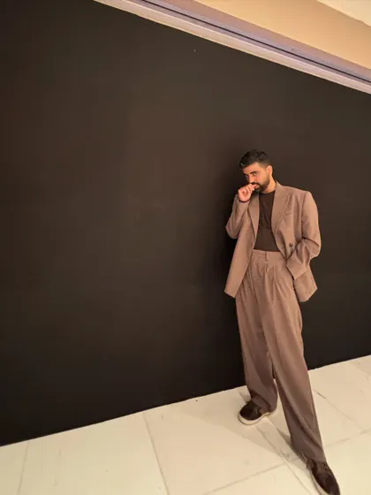 A candid moment from the same event. The all-black background really makes the silhouette of the suit stand out.