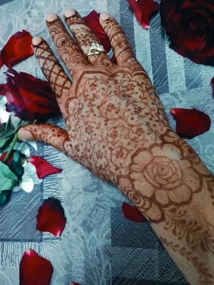 A beautiful shot of a faded floral henna stain, surrounded by rose petals.