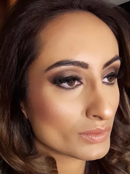 A profile view that highlights the expert contouring and the depth of the eye makeup. Paired with soft curls, this is a go-to look for ultimate glamour.