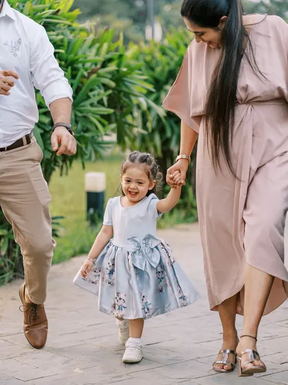 A little girl walking with her parents, full of smiles. These action shots capture the energy of childhood perfectly.
