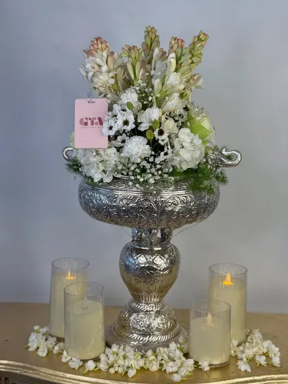 A straight-on view of the silver urli floral arrangement, a perfect centerpiece or welcome gift for Diwali and other traditional festivals.