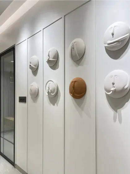 A full view of the hallway with the 3D clay face art installation, showing how it adds character and a sense of humor to the home.