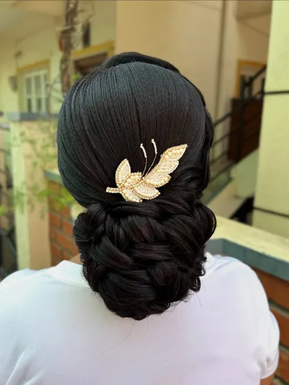 The final look of the braided bun with the butterfly accessory. It's a timeless and sophisticated hairstyle that exudes grace.