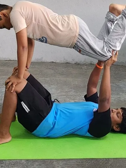 This partner lift requires strong arms from the base and a tight core from the flyer, showcasing a different kind of acro-yoga strength.