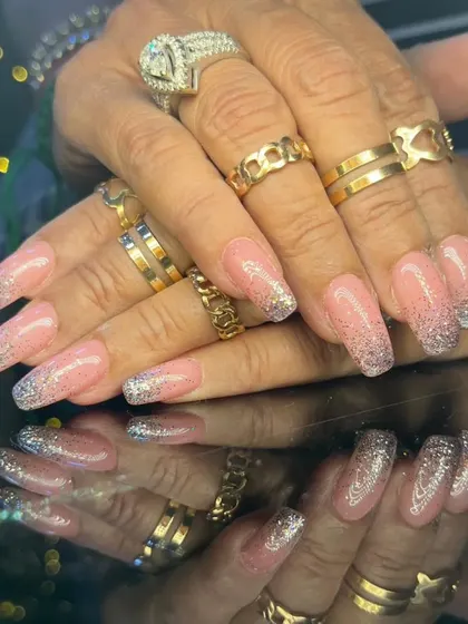 Another view of the sparkling pink and silver glitter ombre nails, styled with lots of rings.