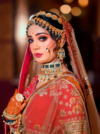 A stunning close-up of a bride with dramatic makeup and heavy jewelry. This portrait is all about glamour and intensity, perfect for a bold bridal look.