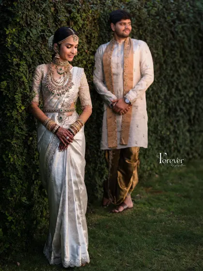 A full-length shot of the bride and groom. Her elegant white saree and my signature dewy makeup create a look of timeless grace.