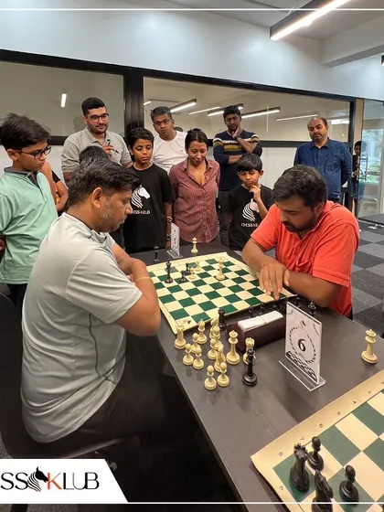 Players and spectators gather around a board to watch a critical game unfold during our Independence Day tournament. The shared passion for chess creates a strong sense of community.