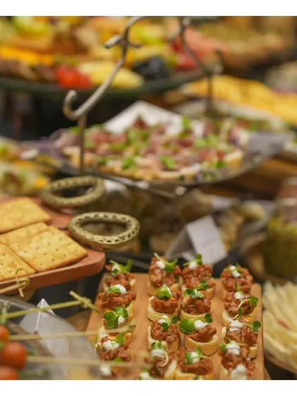 A focused shot on the variety of canapés offered on our grazing board, including different types of bruschetta and crackers with toppings.