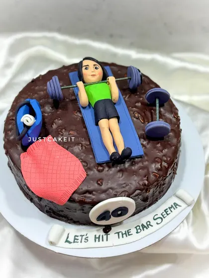 A "Fit at Forty" cake for a fitness enthusiast. This dark chocolate cake is topped with an edible figurine lifting weights at the gym.