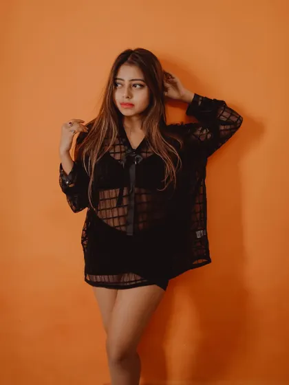This shot captures a classic fashion pose against a vibrant, solid-colored wall, creating a clean and modern look.