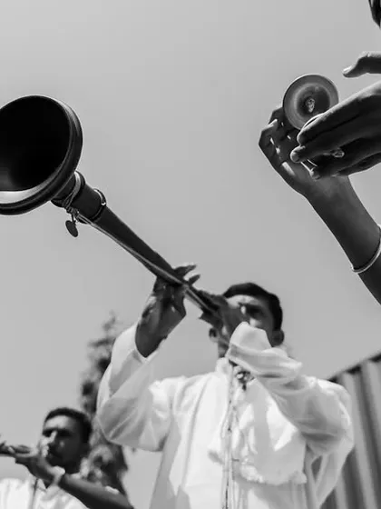 A black and white photo focusing on the traditional musicians playing the nadaswaram, capturing the sounds and culture of a South Indian wedding.