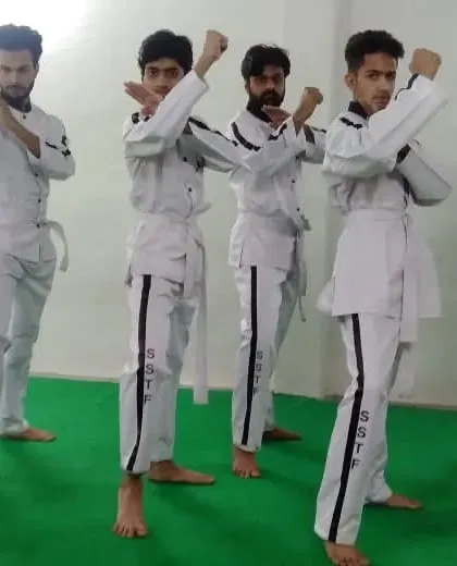 Senior students in uniform, demonstrating a synchronized blocking form. This shows the unity and discipline of our academy.