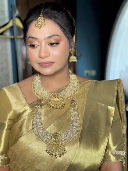 A stunning Haldi look with a traditional South Indian touch, featuring a golden silk saree and temple jewelry.