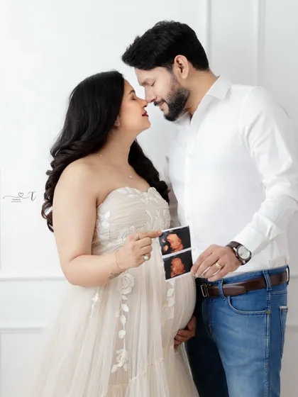 A sweet moment between a couple as they hold up their baby's sonogram. Their loving expressions perfectly capture the magic of this time.
