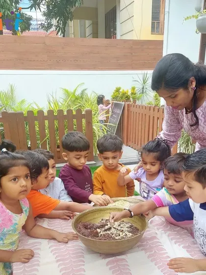 A group of toddlers gathers around a large bowl, eager to help mix the ingredients for the modaks. Even our youngest students participate in our hands-on learning activities.