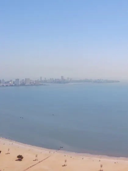 A drone's view of Chowpatty Beach and the vast expanse of the Arabian Sea, with the distant Mumbai skyline visible on the horizon.