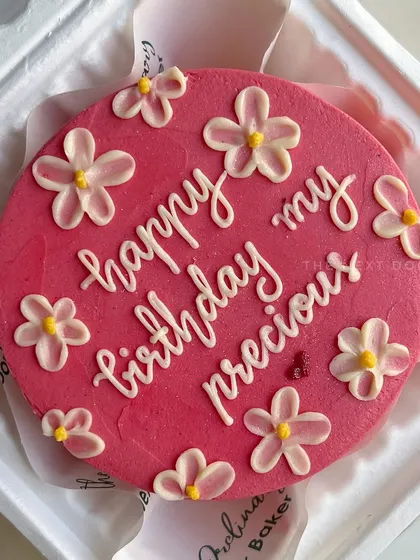 A simple and sweet mini cake with a heartfelt message, "happy birthday my precious," surrounded by delicate hand-piped flowers. Sometimes, less is more.
