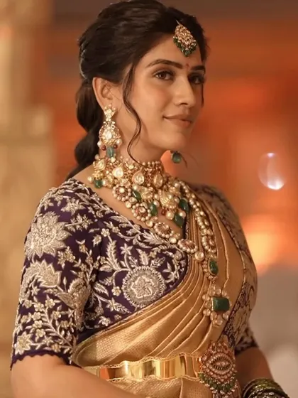 This bride looks radiant in her purple and gold ensemble. The custom blouse with intricate silver embroidery adds a touch of glamour to her look.