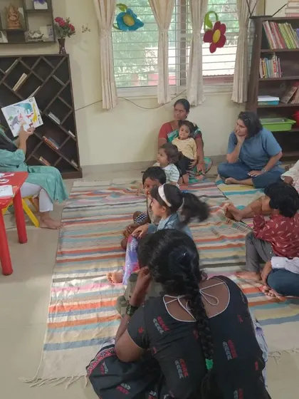 A wide shot of the chameleon story session, with parents sitting with their children.