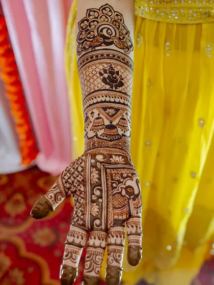 A single-arm view of the bridal mehendi, showing the Ganesha and kalash motifs in clear detail.