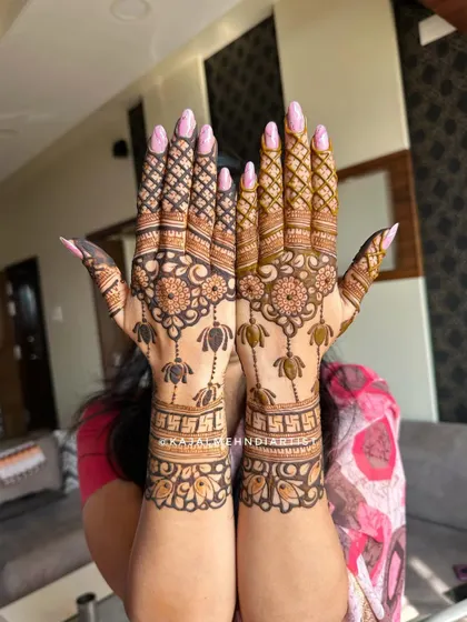 A beautiful backhand design for a festive occasion. It features hanging lotus motifs, Swastik symbols, and intricate grid patterns on the fingers.