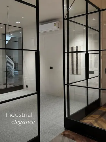 A throwback to the work-in-progress stage, showing the industrial elegance of the black-framed glass partitions. These raw moments capture the foundational structure and play of light before the final layers are added.