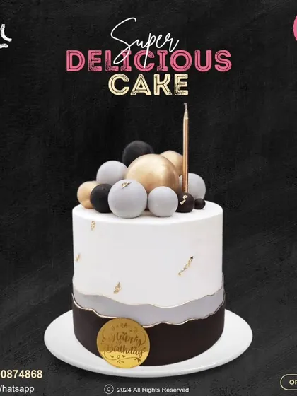 An elegant and modern birthday cake. This design features a sophisticated black, grey, and white color scheme, topped with black, white, and gold spheres and a single candle.