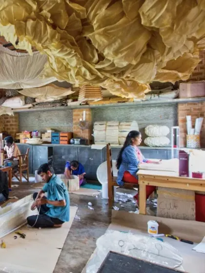Artisans at work inside the Oorjaa paper-making studio. The workshop was designed to be a functional and inspiring space, with high ceilings and ample natural light for detailed craftwork.