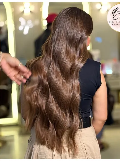 From the back, you can see the seamless flow of this rich brown color. The soft waves and healthy shine make this a truly timeless and elegant look.
