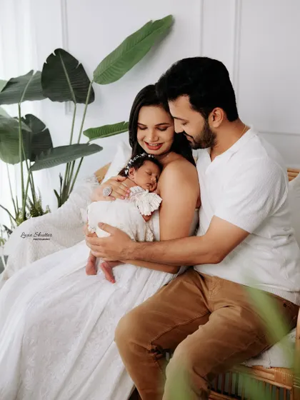 A candid-style family photo, capturing a quiet moment of admiration for their new baby. These natural interactions create the most authentic portraits.
