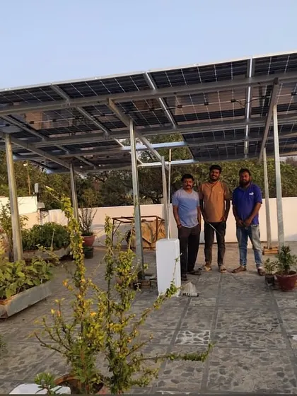 Three of our team members with a customer on his rooftop, showcasing the completed solar installation.
