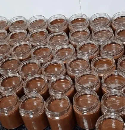 A behind the scenes look at our production line, with dozens of jars being filled with our fresh Hazelnut Cocoa Spread. We make these in large batches to meet demand for festive and corporate gifting.