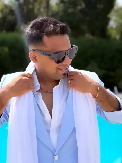 Adjusting my collar, a small gesture of getting into character. The light blue suit with a white scarf is a classic look for a sophisticated wedding event.