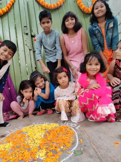 A happy group of children poses with their finished rangoli. Celebrating festivals together helps us appreciate the rich cultural diversity of our community.