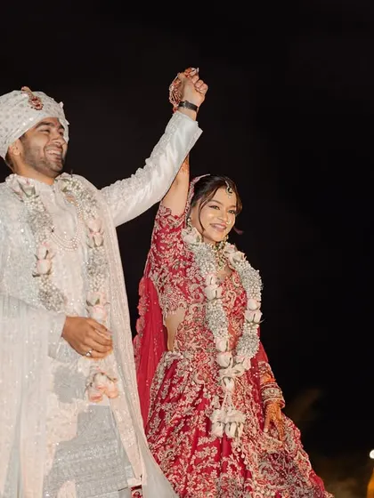 With sparks flying, the couple makes a triumphant entrance, hands raised in celebration. This dynamic shot is full of energy and joy, marking the beginning of their new life together.
