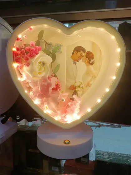 The white version of our 3D heart-shaped LED lamp. It offers a soft, elegant look with white and pink flowers surrounding your personalized photo.