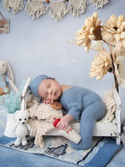 Two little best friends dreaming big. This setup, with the baby in a tiny bed and a furry friend sleeping on the floor, tells a sweet story of companionship.