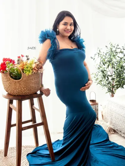 A beautiful solo shot of the mom-to-be with a pop of color from the flower basket. The ruffled sleeves on this blue gown are such a delicate and feminine detail.