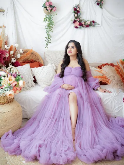 A duplicate of image 348, this dreamy portrait shows a mom-to-be in a flowing lavender gown, surrounded by a beautiful boho setup.