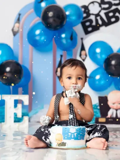 A successful meeting with the cake. This little boss enjoys the sweet rewards of his first birthday.
