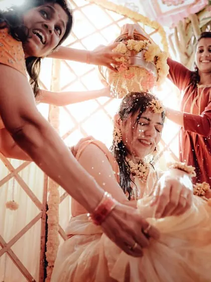 Friends and family joyfully participating in the bride's Haldi ceremony.