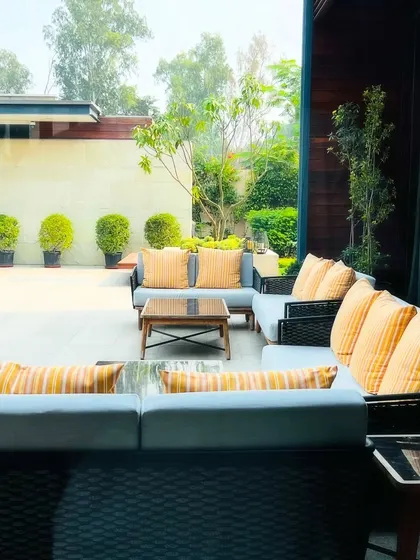 This outdoor lounge area at the Sultanpur property features a large, comfortable sectional sofa. It's a perfect example of how I design functional outdoor rooms that extend the living space of the home.