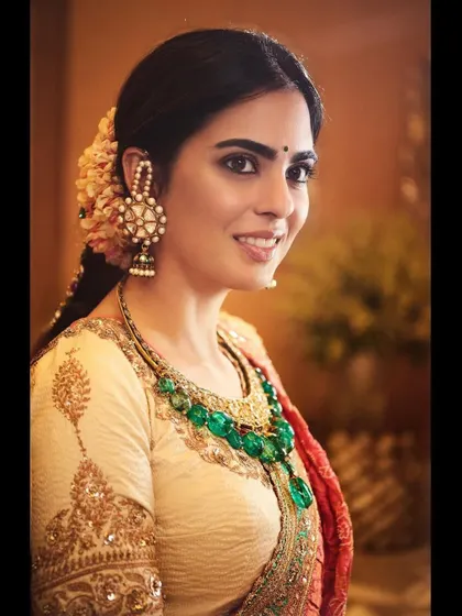A portrait of Isha in the Anuradha Vakil ensemble, highlighting the stunning emerald necklace and traditional jhumkas. The jewelry selection was crucial to complement the rich colors of the outfit.