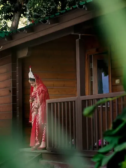 Using creative framing with natural foliage, we captured this candid moment of the bride on her wedding day. This technique adds depth and a sense of intimacy to the portrait.