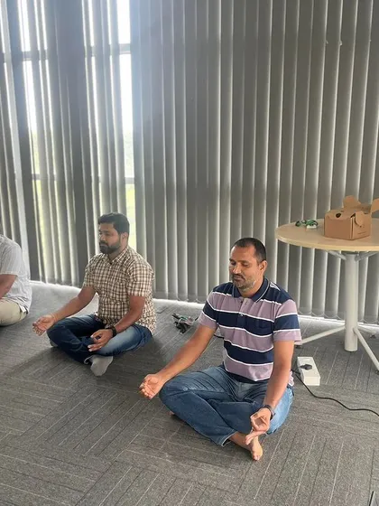 Participants at a corporate workshop settling into a meditative pose. Even a short session can bring a sense of calm and clarity to a busy workday.
