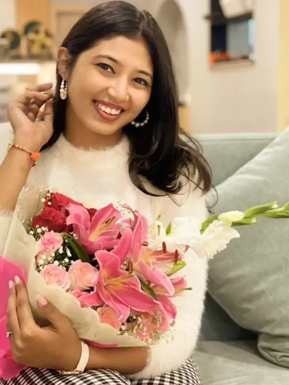 A portrait of our founder, holding a fresh bouquet. This image represents our core mission: to gift smiles and spread joy, one beautiful arrangement at a time.
